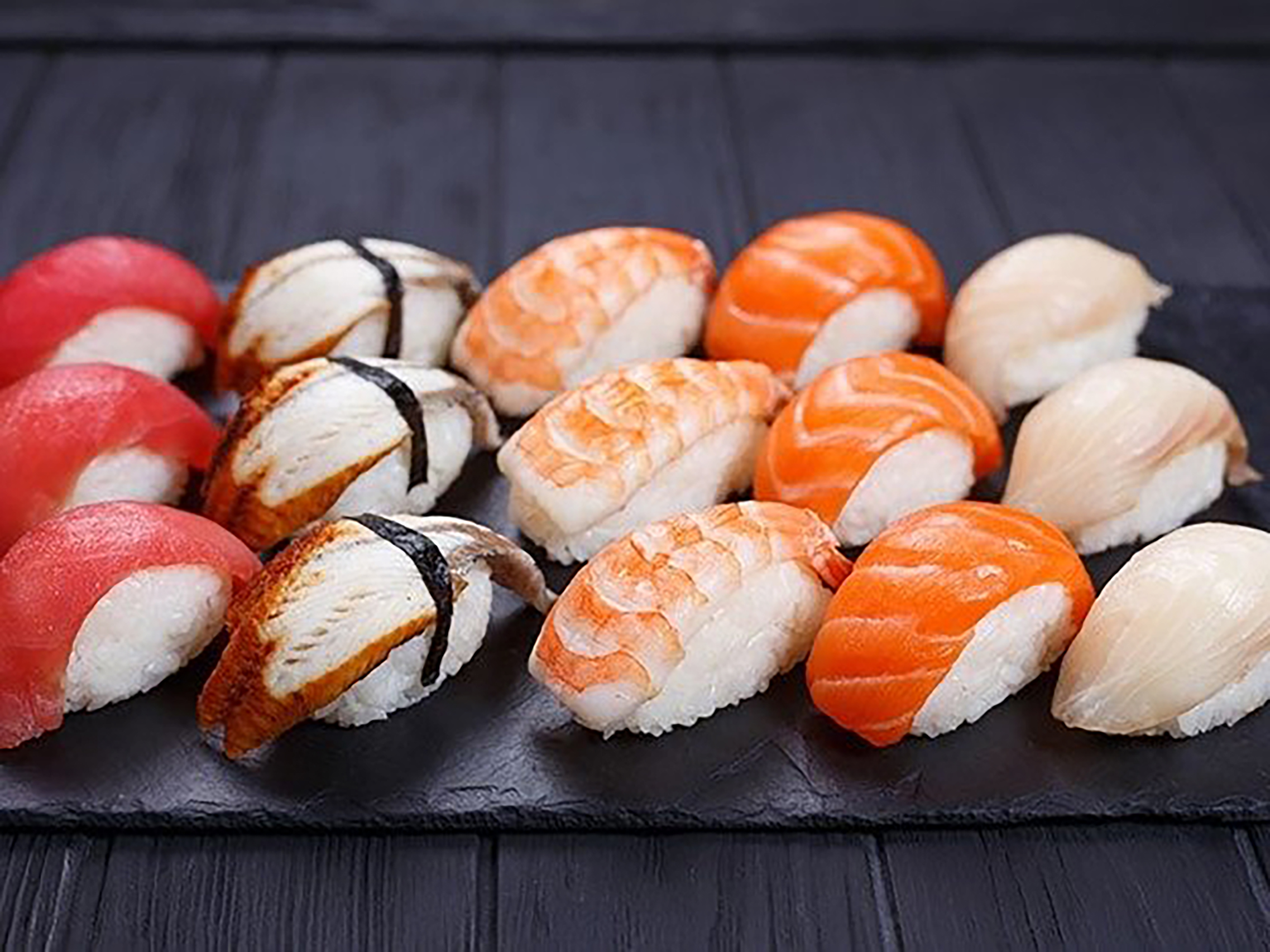 a colorful array of sushi against a slate background