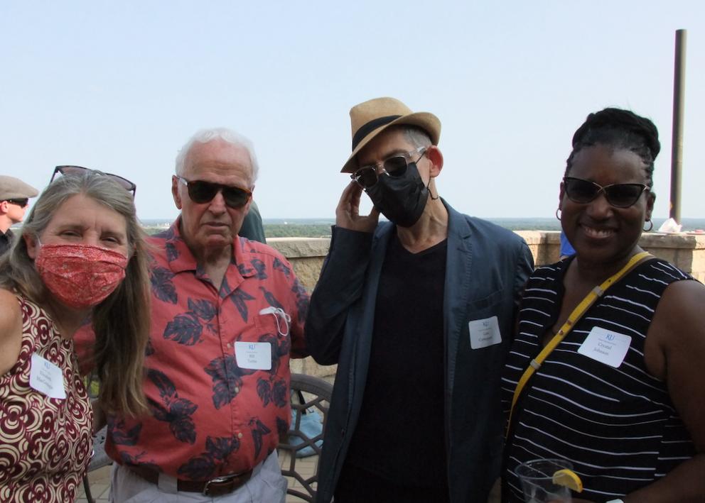 History professors in masks pose for photo on the Oread balcony at the convocation event