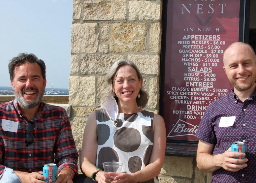 History faculty/staff smile for photo outside on Oread balcony at Convocation event