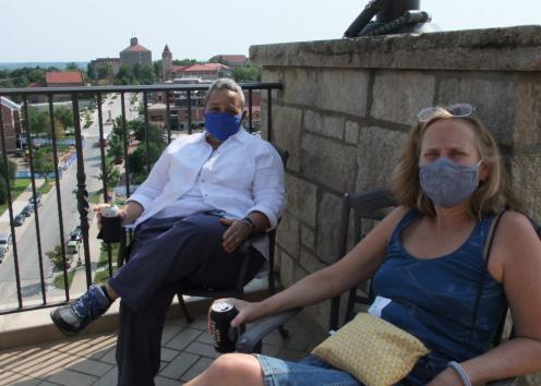 History professors in masks pose for photo on the Oread balcony at the convocation event