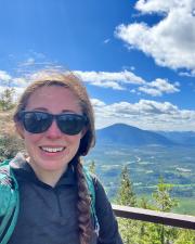 A woman wearing sunglasses with a mountain in the background
