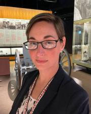 A woman wearing glasses smiling at the camera