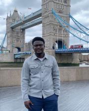 a man standing in front of the tower bridge in London