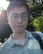 A man wearing a blue polo shirt and glasses smiling at the camera.
