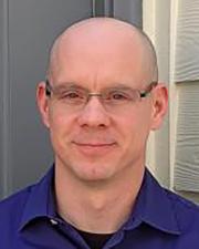 Man wearing glasses and a navy shirt.