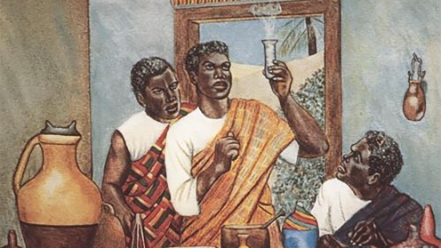 A man holding a beaker to examine the contents with two assistants.